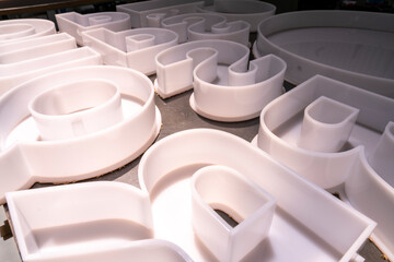 High-gloss acrylic face-lit letters arranged for illuminated signage fabrication