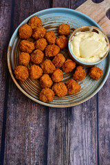 Crispy  deep fried   chicken  popcorn  nuggets and french fries . Breaded  with Cornflakes chicken  Breast fillets  with chilly peppers and fresh   basil on wooden rustic background