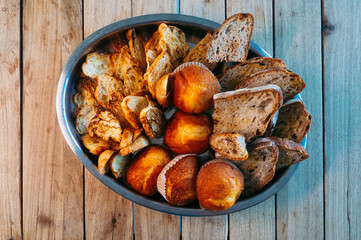 Basket with assorted bread and muffins on table.