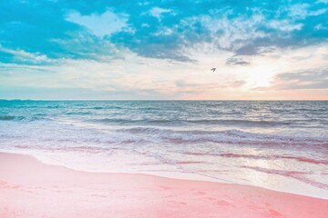 Colorful sunset viewed from the pink sea beach with soft waves