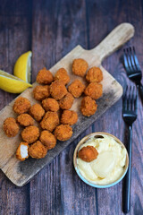 Crispy  deep fried   chicken  popcorn  nuggets and french fries . Breaded  with Cornflakes chicken  Breast fillets  with chilly peppers and fresh   basil on wooden rustic background