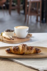 Warm croissant and cappuccino serving during breakfast in cafe