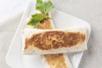 Grilled tortilla wraps with parsley on white plate