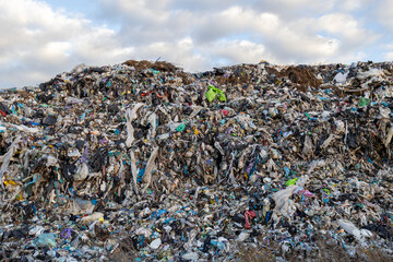 A large landfill is overflowing with garbage, showcasing the extent of pollution caused by waste