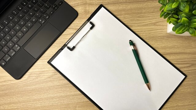 A minimalist workspace&mdash;a laptop, a blank sheet of paper, and a pen. A symbol of getting started, planning, ideas, and productivity.