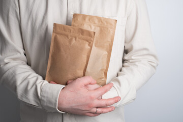 Kraft paper packaging in a mans hands. Packaging for coffee, cosmetics. Packing closeup. Product...