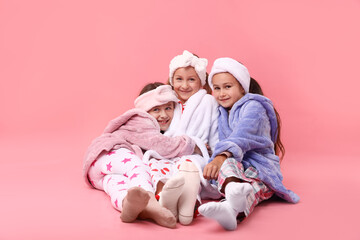 Cute children in pajamas on pink background