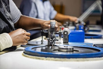 african workers, diamond polisher at work, using a polishing wheel to shape and refine a rough diamond, brillianteering