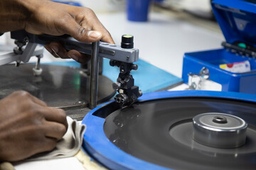  african workers, diamond polisher at work, using a polishing wheel to shape and refine a rough diamond, brillianteering