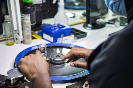 african workers, diamond polisher at work, using a polishing wheel to shape and refine a rough diamond, brillianteering