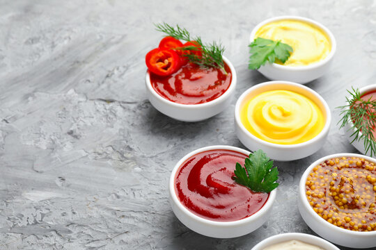 Different sauces in bowls and ingredients on grey textured table, closeup. Space for text - Powered by Adobe