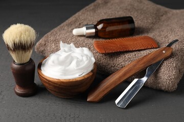 Different barber's tools on grey wooden background, closeup