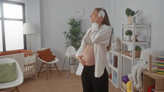 Pregnant woman enjoying music with headphones in cozy baby room surrounded by toys and crib
