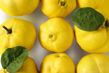 Fresh quinces with green leaves on white background, flat lay