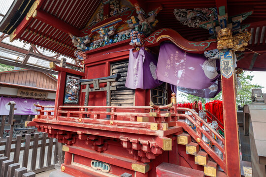 View of an ornate, red-lacquered structure adorned with intricate carvings and purple drapes stands as a testament to cultural heritage, Narita, Chiba, Japan.