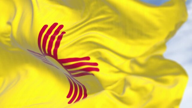 New Mexico state flag waving with red Zia sun symbol on yellow background