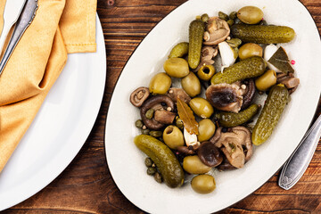 Plate with salty snacks on rustic wooden table.