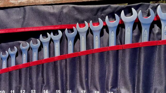 Set of Metal Wrench Spanners in a Red and Black Tool Roll Bag. Dynamic Shot of Tools for Repair, Construction, and Mechanics.