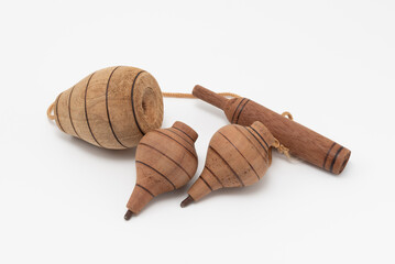 Set of two vintage wooden spinning tops and a cup-and-ball toy (bilboquet), connected by string, isolated on a white background. Symbolizes traditional games, childhood, and skill.