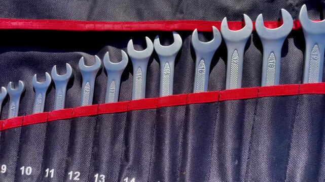 Set of Wrench Spanners with Size Markings in Pockets of a Black Cloth Bag