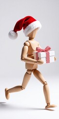 A wooden figure wearing a red Santa hat runs while carrying a wrapped gift, capturing the festive spirit of Christmas in motion.