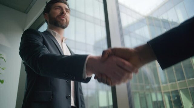 Caucasian business man leader boss talking with African American client in office shaking hands teamwork welcoming greeting conclude deal. Two diversity multiracial businessmen colleagues handshaking