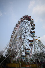 Closeup of multi-coloured Giant Wheel during Dussehra Mela in Delhi, India. Bottom view of Giant Wheel swing. Ferris wheel with colourful cabins during evening time.