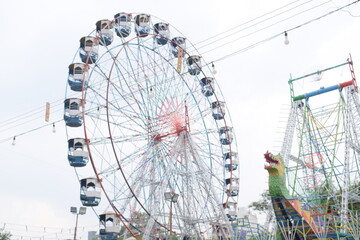 Closeup of multi-coloured Giant Wheel during Dussehra Mela in Delhi, India. Bottom view of Giant Wheel swing. Ferris wheel with colourful cabins during evening time.