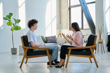Young man in mental therapy session in office of social psychologist,counselor