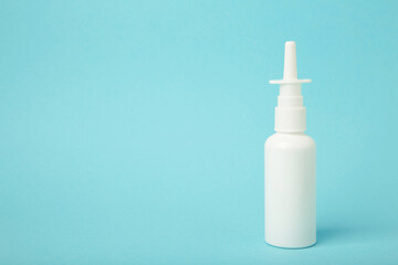 Nasal drops medicine bottle on blue background. Space for text
