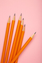 Graphite pencil with eraser on pink background. School stationery