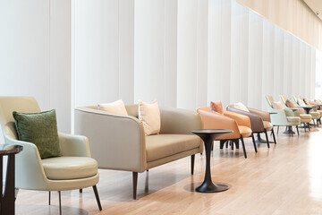 Modern lounge seating minimalist interior soft lighting neutral color palette contemporary chairs cozy cushions clean lines wooden floor waiting area airy space. Modern lounge seating minimalist