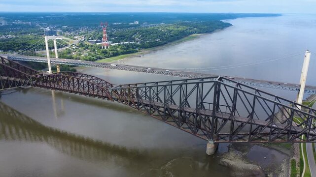 Bird's-eye view of two generations of bridges. The longest cantilever bridge in the world, the Quebec Bridge, and the Pierre-Laporte Suspension Bridge spanning the St. Lawrence River, Quebec, Canada.