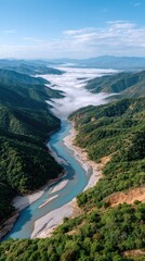 Serene Blue River Meanders Through Lush Green Mountains Under a Sky Filled With Wispy Clouds and Low Fog Rolling Through the Valley