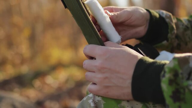 Bandage a wound. A soldier in the forest. First aid kit. Slow motion. High quality 4k footage