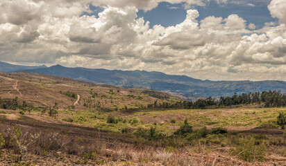 Naklejka premium Composite panorama of the landscape of the La Candelaria desert, with dense bright clouds at the horizon, in the eastern Andean mountains of central Colombia, near the town of Raquira.