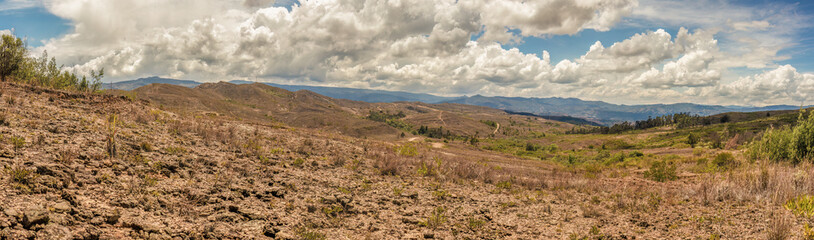 Composite panorama of the landscape of the La Candelaria desert, with dense bright clouds at the horizon, in the eastern Andean mountains of central Colombia, near the town of Raquira.