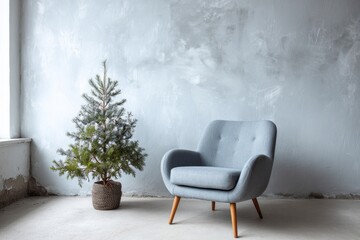 Fototapeta premium A cozy armchair and a small evergreen tree stand against a textured wall.