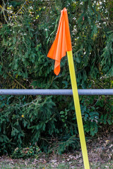 Orangene Eckfahne mit gelbem Pfahl am Sportplatz