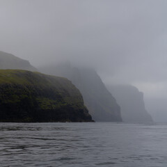 view of the iconic Vestmannabjorgini or Vestmanna Cliffs on Streymoy Island in the Faroe Island Archipelago on a foggy and overcast day