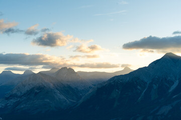 Majestic mountain range basked in soft, ethereal sunlight during sunrise.