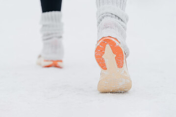 young caucasian woman running in park in winter, sneakers close-up view,, back view, active lifestyle concept, jogging in winter, sports life, copy space