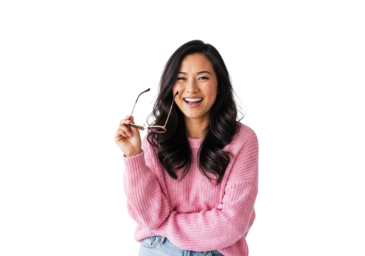 Smiling woman in a pink sweater holding glasses and enjoying a cheerful moment in a bright setting