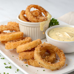 Crispy golden onion rings with delectable dipping sauce tempt taste buds now