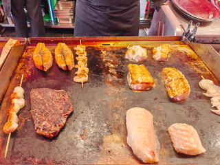 A large choice of various seafoodsfried on a plancha at the fish market in Bergen
