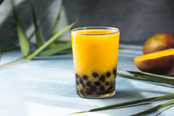 Mango smoothie with boba pearls, creamy mango lassi bubble tea, tropical summer drink