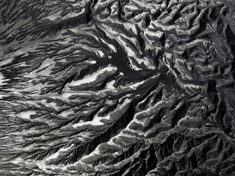 Aerial view of stark, undulating terrain reveals nature's artistry in contrasting light and shadow, Mount Bromo, East Java, Indonesia.