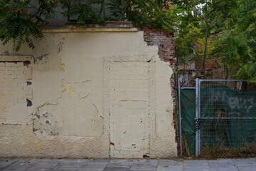Texture of a brick wall with old, peeling paint in some partially ruined buildings