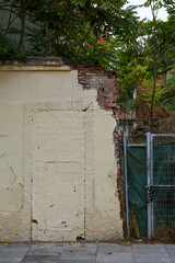Texture of a brick wall with old, peeling paint in some partially ruined buildings