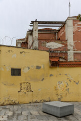 Texture of a brick wall with old, peeling paint in some partially ruined buildings